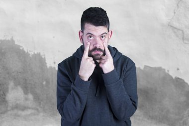 parmakları ile gözlerini açarak ve kameraya bakarak bir adam 