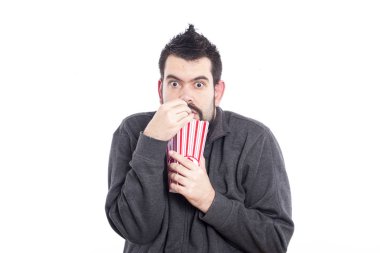 pop corn kutusu beyaz arka plan üzerinde tutarak ve kameraya bakarak adam 