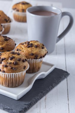 ahşap masa peçete ile sabah kahvaltı Kupası ve cupcakes plaka üzerinde .kakao içmek 