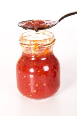 açılan cam kavanoz konserve rendelenmiş kırmızı domates ve kaşık ile 
