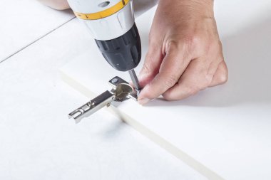 Closeup görünümünü parmaklar, kapı menteşesi düzeltmek için tornavida kullanarak adam