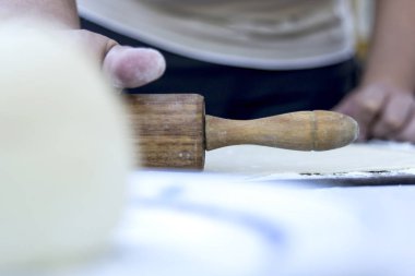 ahşap oklava ile mutfak masasında hamur hazırlama kişinin görüntüsü kırpılmış