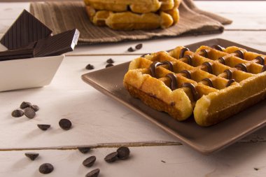 plaka, çikolata şurubu ile pişmiş Belçika Waffle kase masada çikolatalı dilimler 