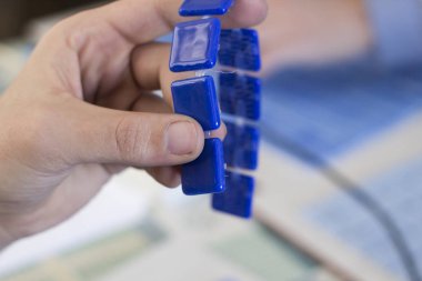 mavi mozaik karolar ile çalışan kişinin görüntüsü kırpılmış