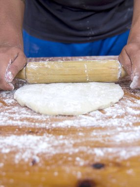 adam ahşap oklava ile mutfak masasında hamur hazırlama görüntü kırpılmış