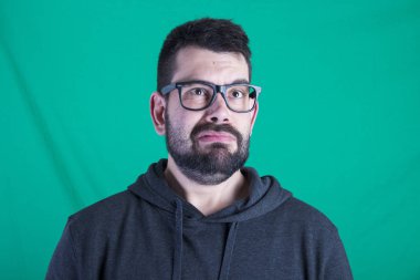 Adamın yeşil arka plana karşı hayal kırıklığına yüzünü 