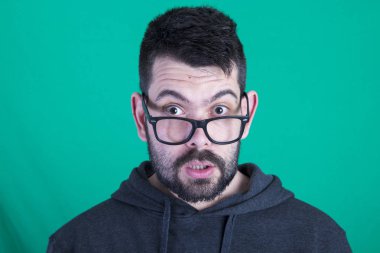 şok adam anız ayakta yeşil bir arka plana dayanır 