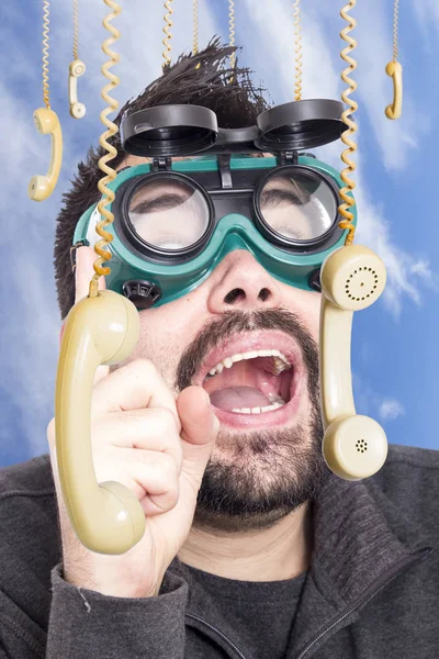 Zaskoczony Mężczyzna Zgrzewania Sobie Okulary Otoczony Przez Powieszenie Telefony — Zdjęcie stockowe