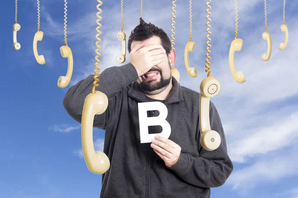 Homme Entouré Téléphones Suspendus Tenant Lettre Alphabet Couvrant Les Yeux — Photo