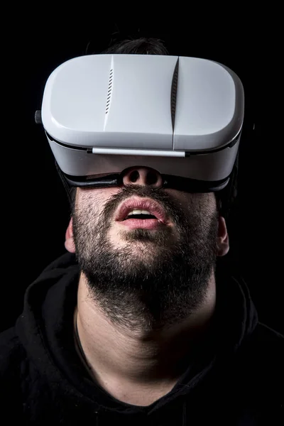 man wearing VR glasses in darkness, virtual reality simulation