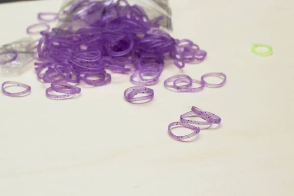 purple rubber bracelet bands on table