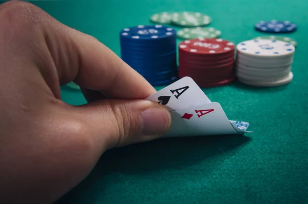 チップを持つ緑のカジノ テーブルでカードを持っている手の部分ビュー — ストック写真