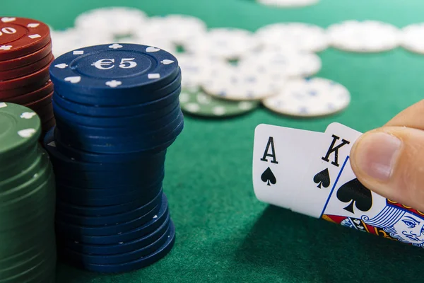 カード 緑のテーブルのカジノでトランプを持っている手のトリミングされた画像 — ストック写真