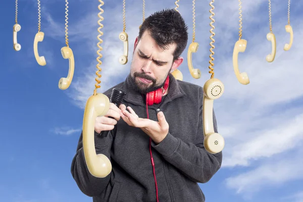 Homme Contre Ciel Entouré Téléphones Suspendus Ancienne Combinés Tenant Microphone — Photo