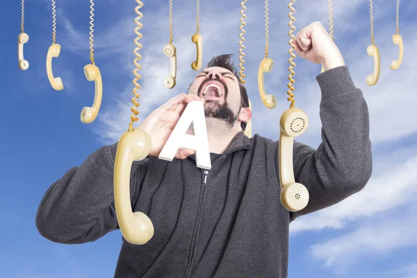 Hombre Gritando Rodeado Teléfonos Colgantes Sosteniendo Letra Del Alfabeto —  Fotos de Stock