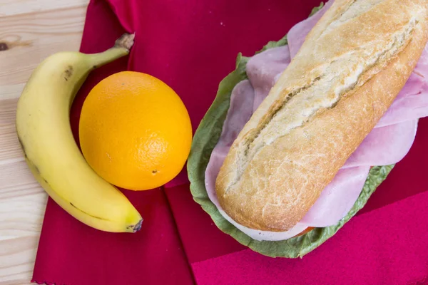 냅킨에 테이블 오렌지와 바나나 과일에 베이컨 고기로 샌드위치 — 스톡 사진