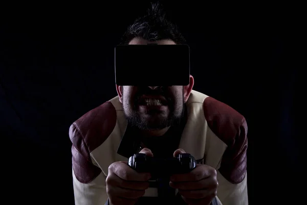 scared man wearing VR glasses in dark studio