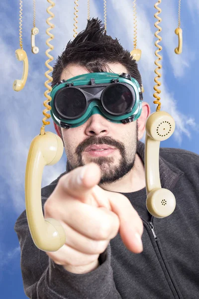 Hombre Serio Con Gafas Soldadura Rodeado Teléfonos Colgantes Apuntando Con —  Fotos de Stock