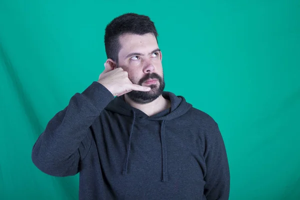 Hombre Vistiendo Sudadera Con Capucha Posando Sobre Fondo Verde Imaginando —  Fotos de Stock