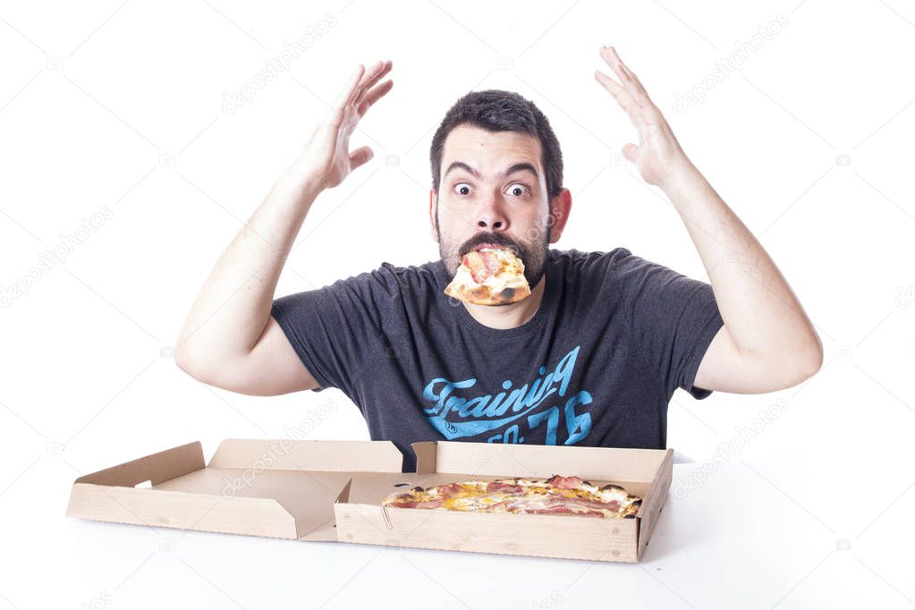 caucasian man eating pizza from box in studio, pizza slice in mouth 