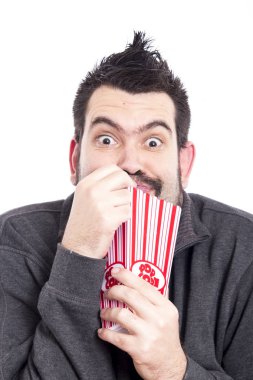 pop corn kutusu beyaz arka plan üzerinde tutarak ve yeme, kameraya bakarak adam 