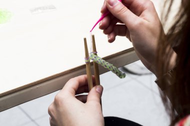 Kadın el örgü iğneleri, kauçuk şeritler ve çengelli lastik bant bilezik yapımı 