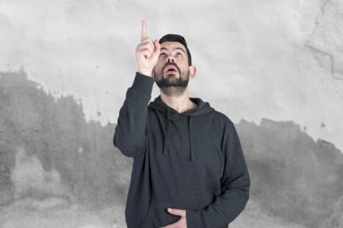 Beyaz adam parmak işaret ve yukarıya bakıyor gri kapşonlu hayran 