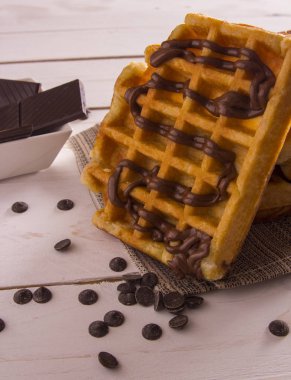 Çikolata şurubu, çikolatalı dilimler beyaz kase ile Belçika Waffle 