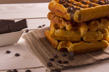 Çikolata şurubu, çikolatalı dilimler beyaz kase ile Belçika Waffle 