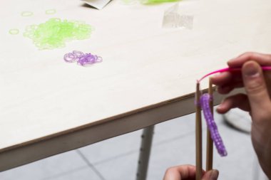 Kadın el giysiler pimleri ve lastik bantlar ile elastik bilezik yapımı kısmi görünümü 