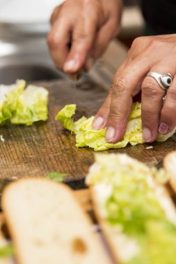 Yemek, yeşil marul yaprakları ahşap tahta üzerinde kesme Şef closeup görünümü 