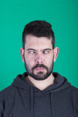 yeşil arka planı stüdyosunda poz şaşı gözlü esmer adam 