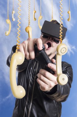 VR gözlükle ve eski moda telefon yakışıklı asma gökyüzü karşı oyun joystick ile oynayan adam