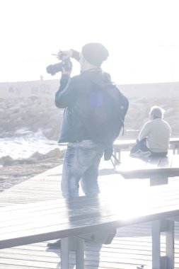 Dijital fotoğraf makinesi yapımı ile genç adam şehir dolgu üzerinde gündüz yakalar.