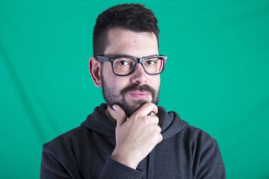 yeşil duvar kameraya bakarak karşı ciddi düşünceli insan portresi 