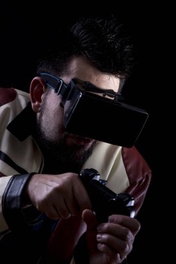 VR gözlük takan ve karanlıkta oyun joystick kullanarak bir oyun adam 