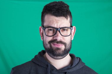 yeşil bir arka plana dayanır adamın mutsuz yüzü 