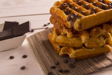 Çikolata şurubu, çikolatalı dilimler beyaz kase ile Belçika Waffle 