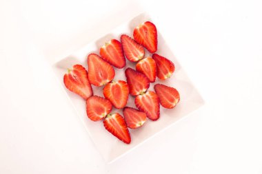 Studio plaka üzerinde kırmızı çilek dilimlenmiş 