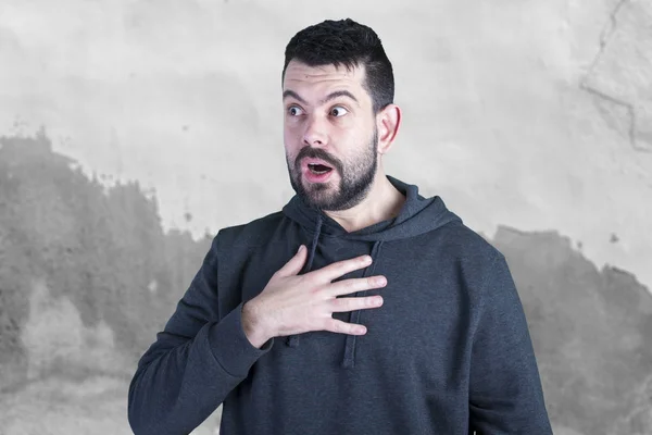 caucasian man with opened mouth, scared guy standing against grey wall