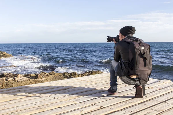 Fotoğrafçı adam fotoğraf makinesi fotoğraf denizde su çekme ile şapkalı 