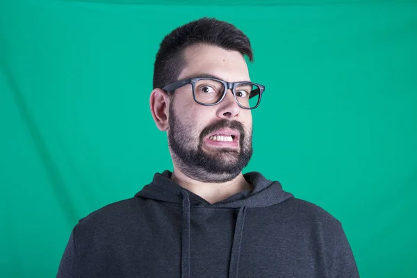 frightened man with stubble wearing glasses and looking at camera in studio