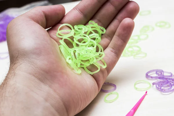 hand holding green rubber bracelet bands