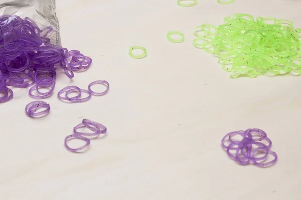 violet and green rubber bracelet bands on white table surface