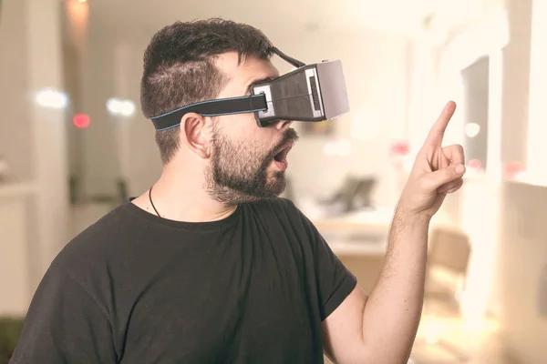 shocked man with opened mouth wearing VR glasses at home in room