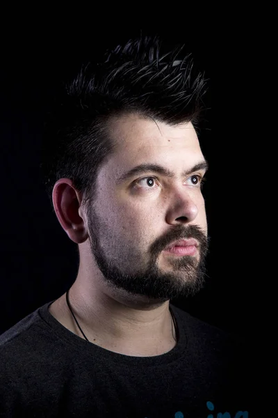 caucasian man with stubble in studio with black background