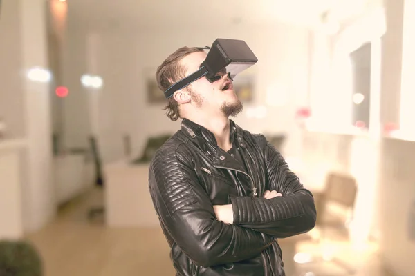 shocked man wearing VR glasses and playing in virtual reality simulation at home