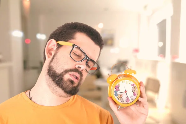 睡眠胡子的白种人持有橙色闹钟 — 图库照片