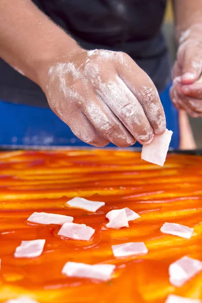 Şef pizza domuz eti et dilimleri ve domates salamura hazırlama