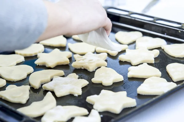 person preparing Christmas Cookies on Sheet pan